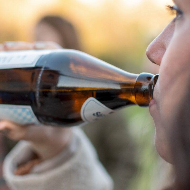 woman drinking alchol out of beer bottle - alcoholic nose