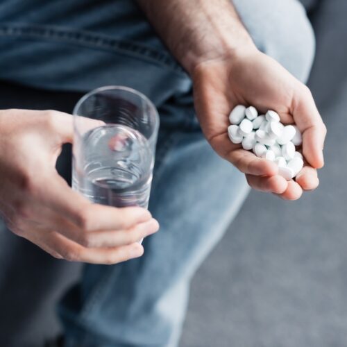 man holding opioid pills